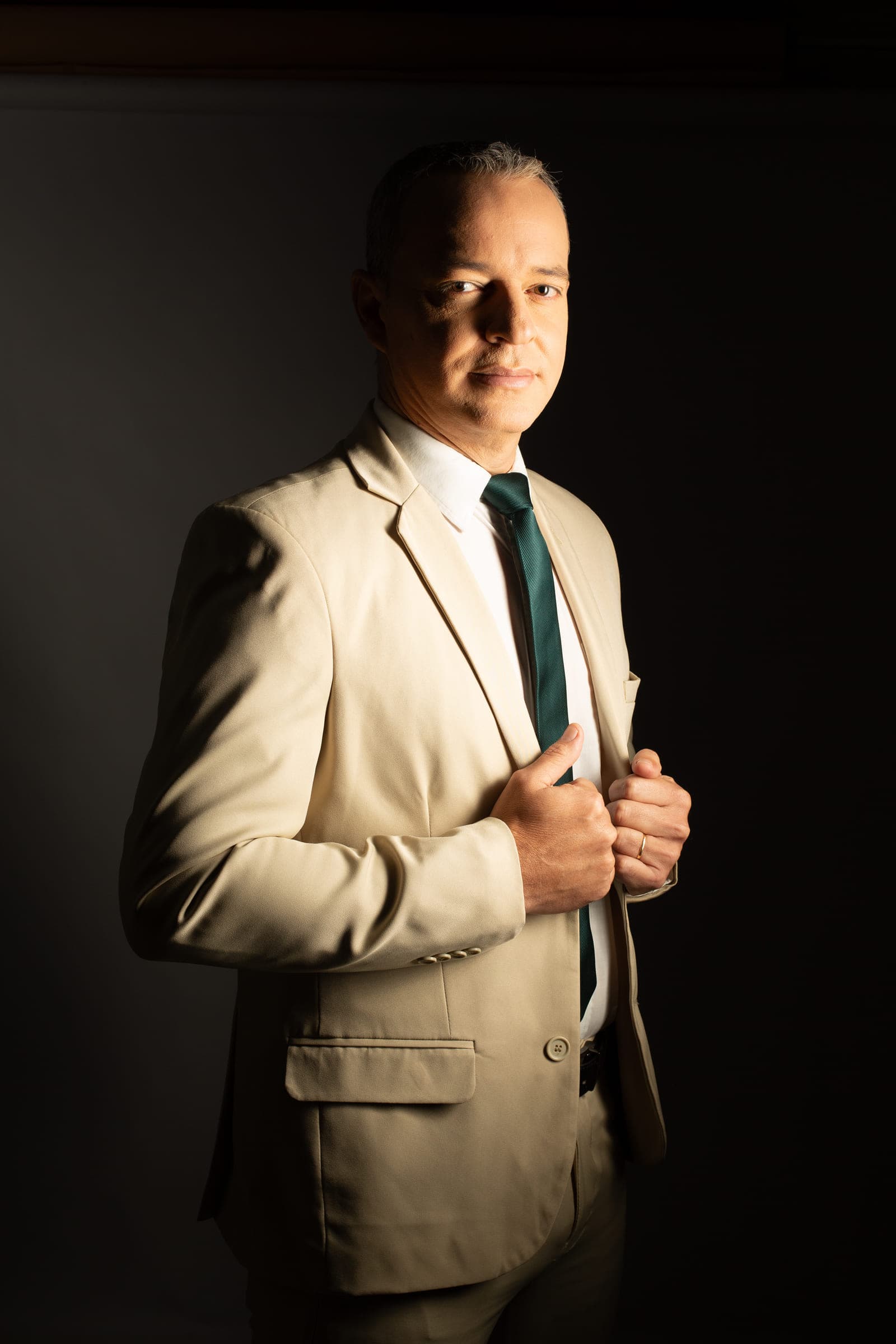 Paulo Crispim em retrato profissional, de terno claro e gravata